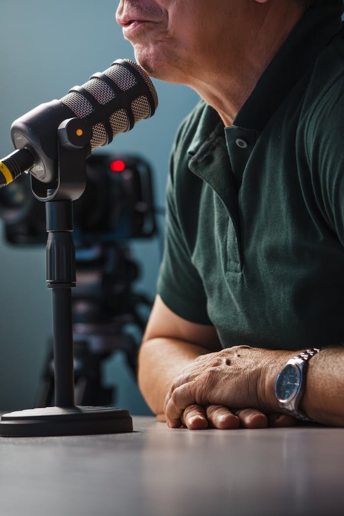 menu-01 A detailed view of a professional podcast setup featuring a microphone and video camera, highlighting interview equipment.